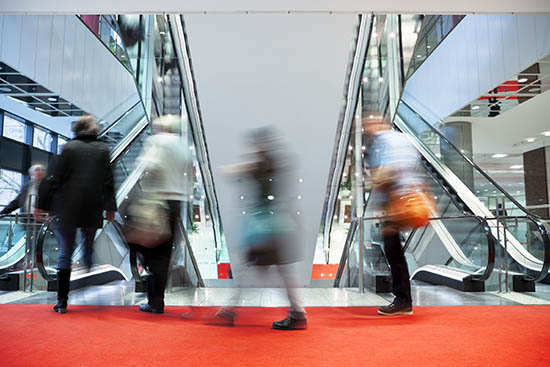 Blurry people at the top of an escalator