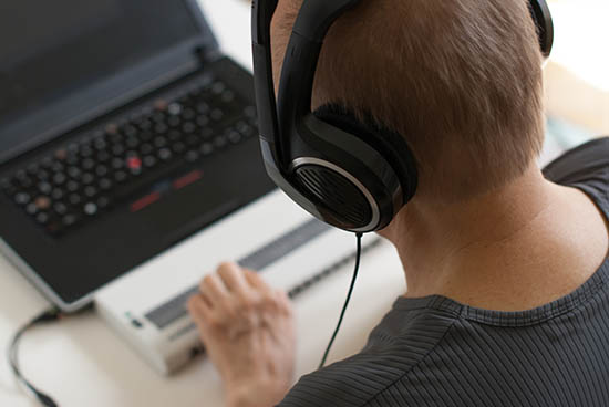 A man with earphones and an electronic braille reader