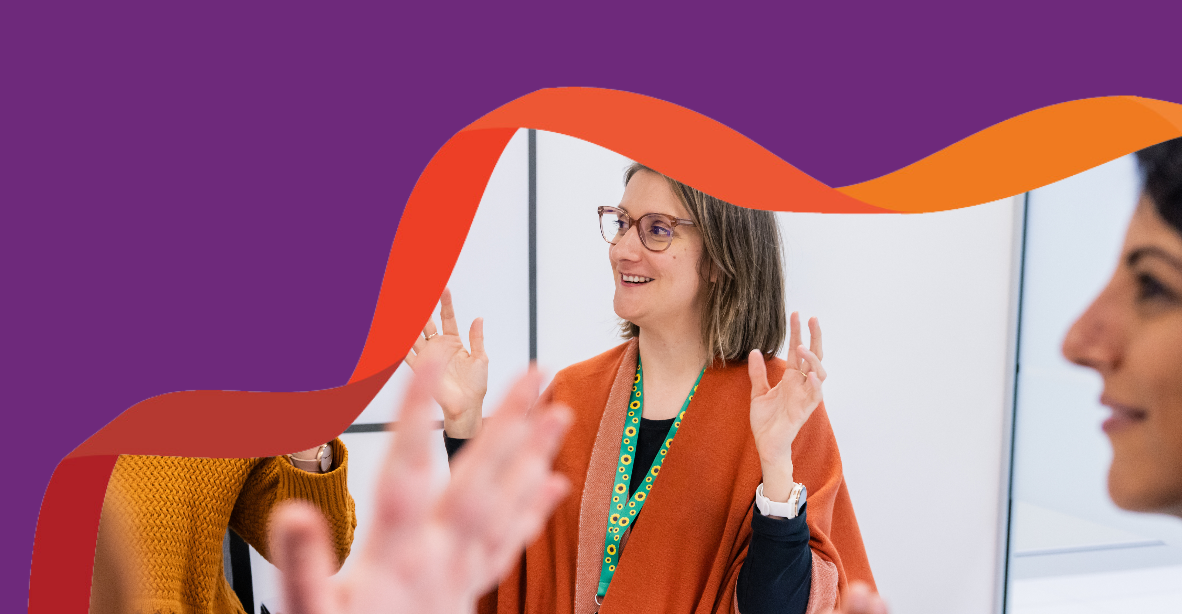 Hayley, a woman is in a boardroom, clapping in Auslan